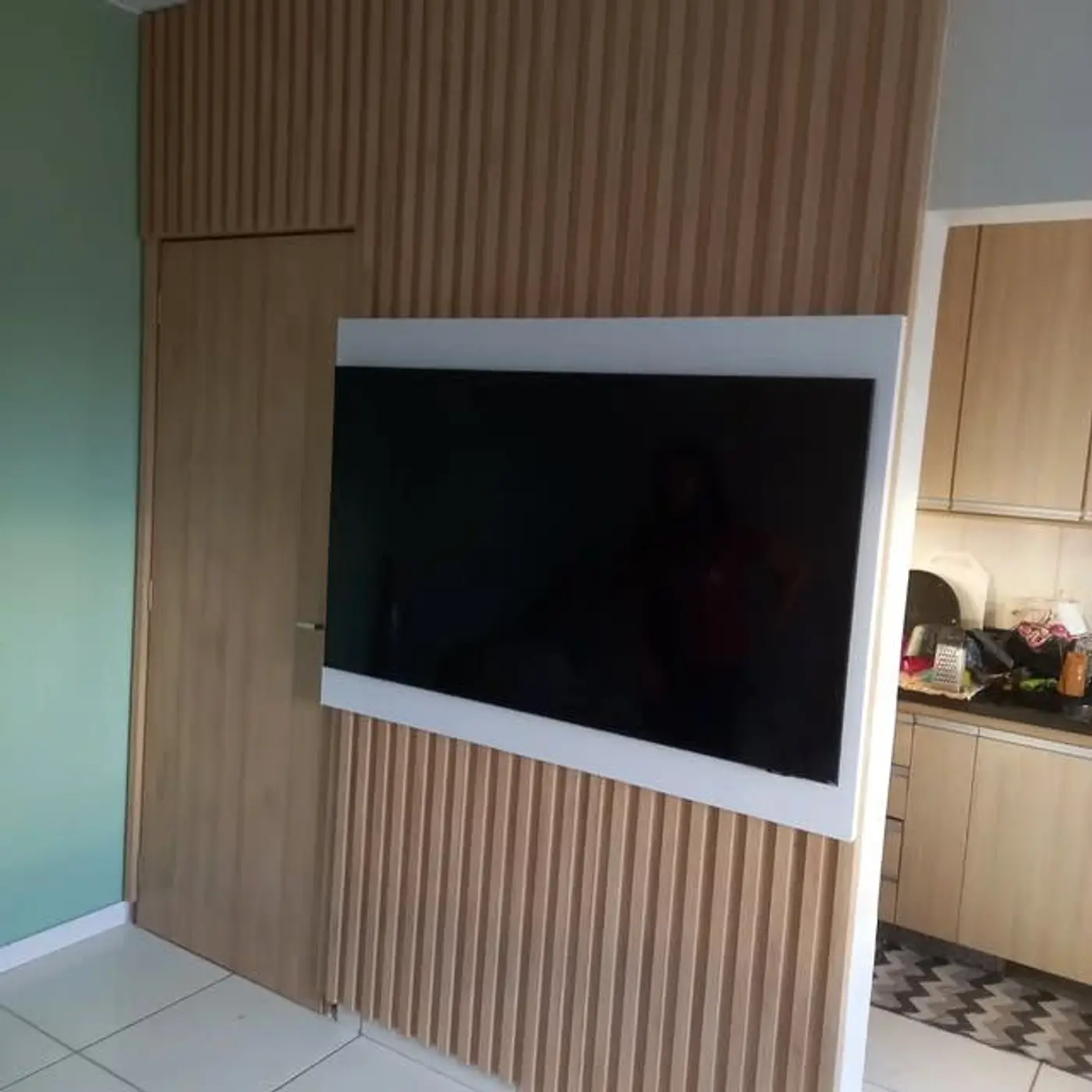 Painel ripado Carvalho Treviso com porta oculta, obra da Opção Planejar
